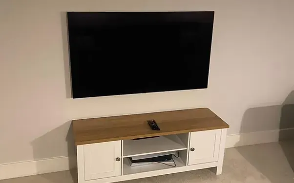 TV mounted in a loft room above a media unit
